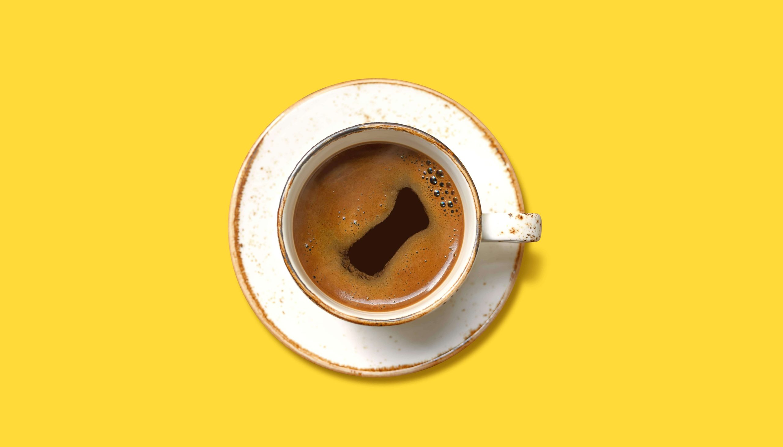 Tasse de café blanche sur un fond jaune