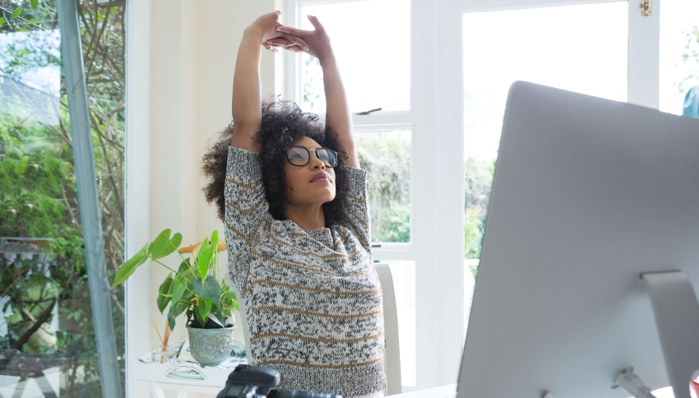 Une femme qui est assise et qui s'étire au travail