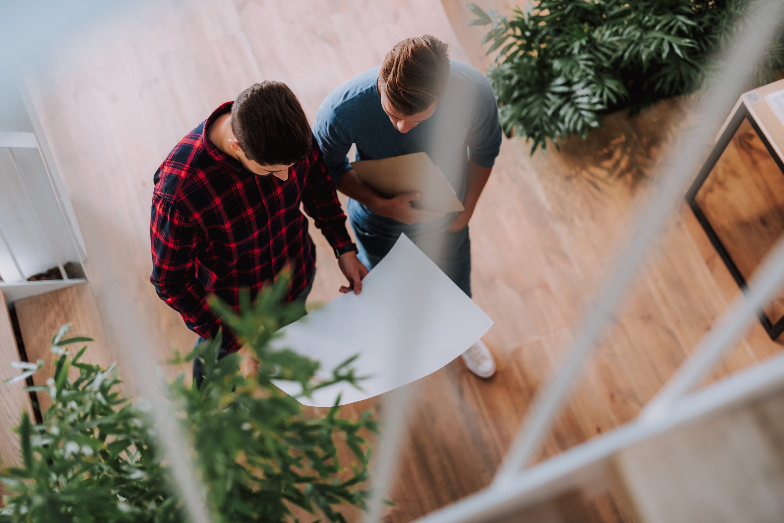 Deux hommes qui regardent un projet, pris de haut