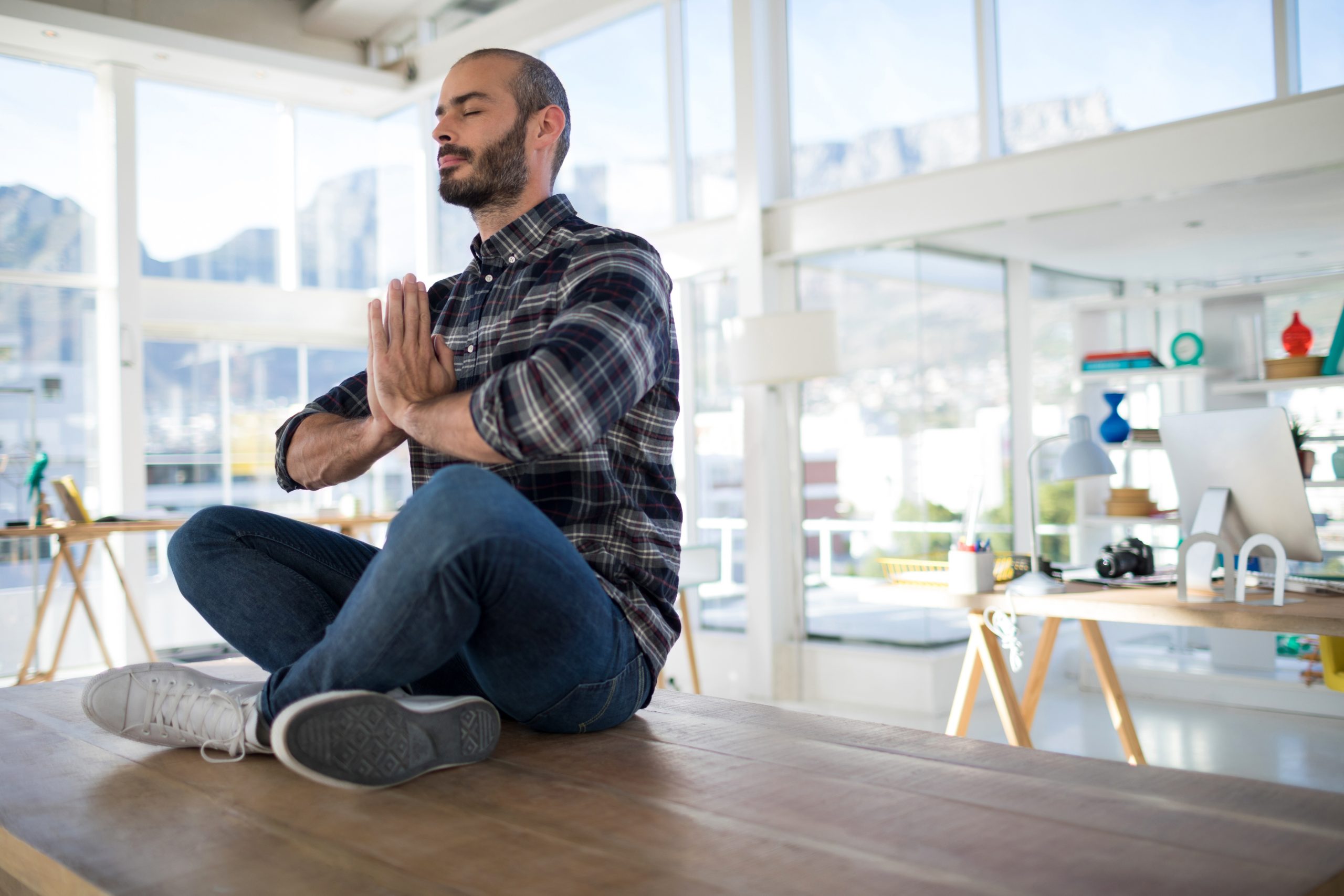 Homme qui est assis en tailleur sur la table pour rester zen