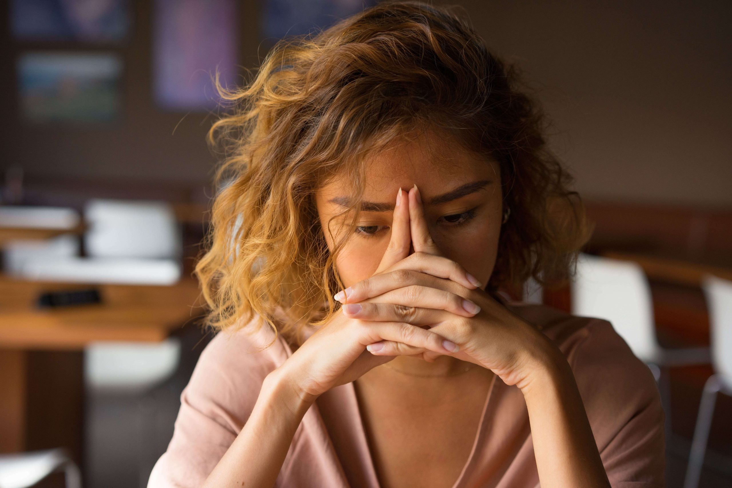 Femme qui stresse et qui entremêle ses doigt en les posant contre son visage