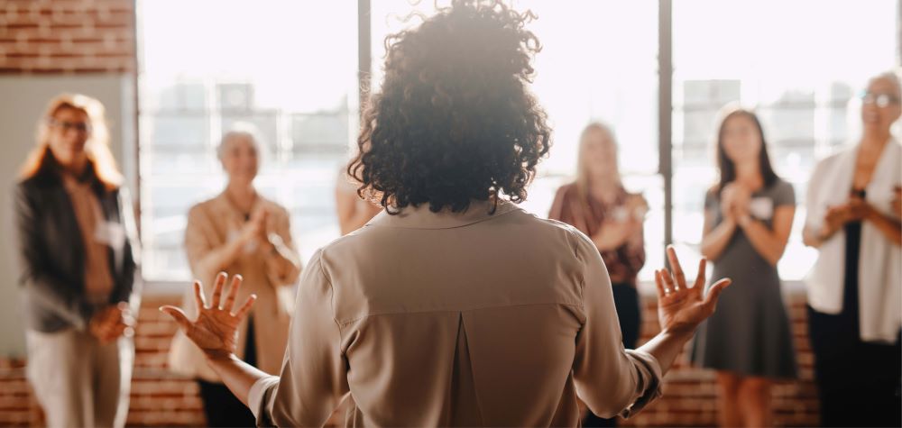 Femme de dos qui motive son équipe floutée